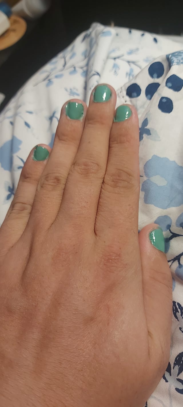 Photo of a hand with green painted nails